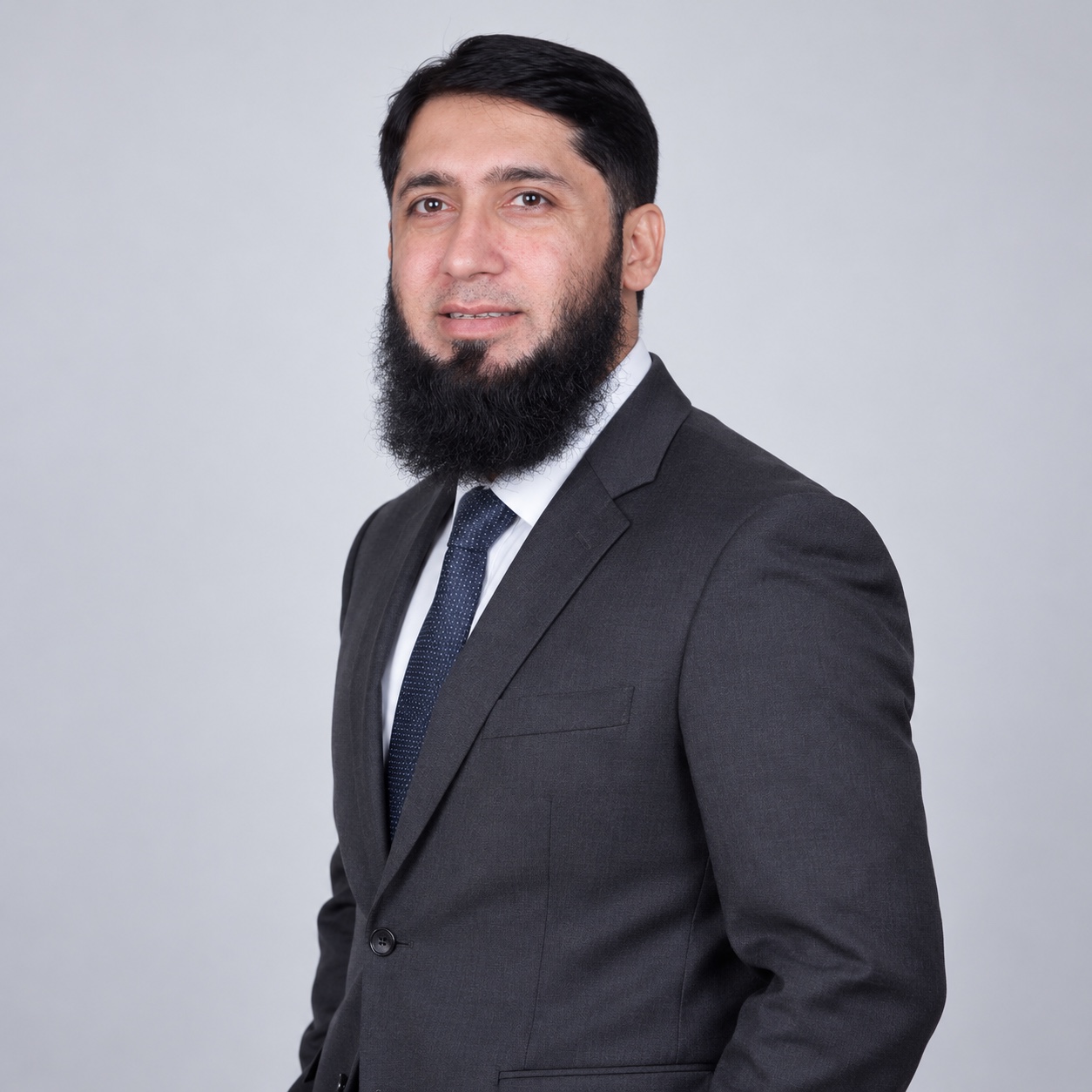 Mr. Yasir Qayuum in a grey suit